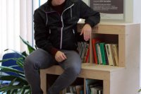 Filip Galko demonštruje, že na knižnici sa dá aj sedieť