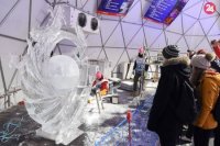 Na snímke diváci sledujú ako člen japonského tímu dokončuje ľadovú sochu.