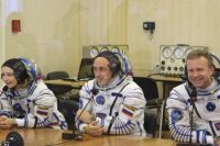 Na snímke zľava ruská herečka Julija Peresildová, ruský filmový režisér Klim Šipenko a ruský kozmonaut Anton Škaplerov sa rozprávajú s príbuznými cez bezpečnostné sklo pred štartom kozmickej lode Sojuz MS-19.