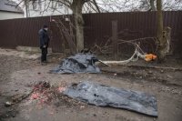 telesné pozostatky obetí, ktoré sú prikryté čiernymi  vrecami neďaleko vraku zostreleného lietadla v Kyjeve