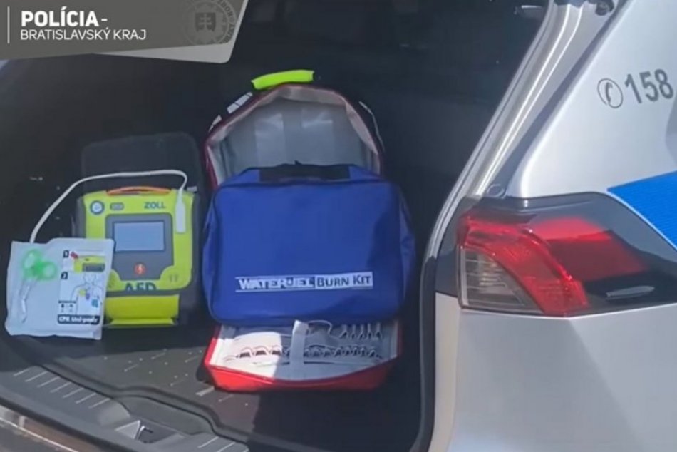 Policajti nosia v aute defibrilátor.
